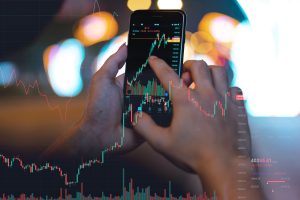 image of a man's hand using his phone to check the stock exchange